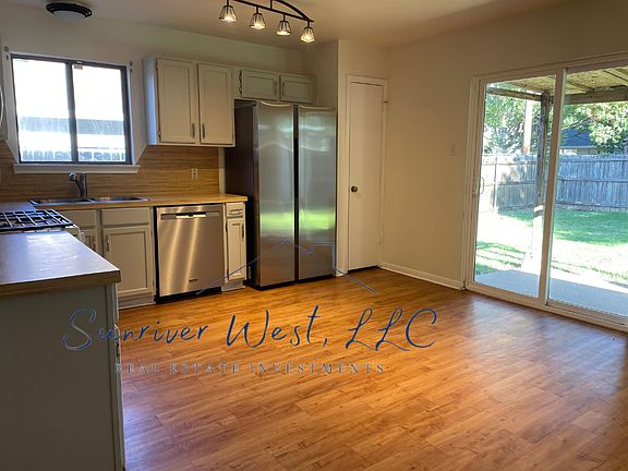 Kitchen has gas stove, dishwasher, and refrigerator.