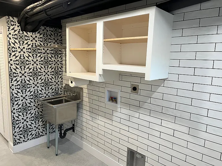 Stainless steel sink, and storage over washer/dryer.