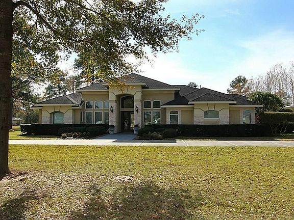 Custom one story 4 bedroom home with stucco and stone on 5 wooded acres with pond.