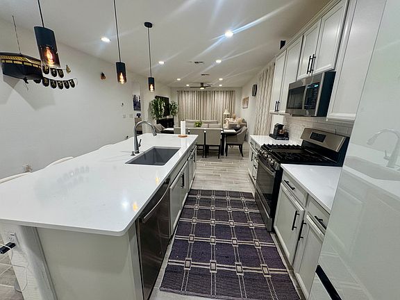Upgraded kitchen featuring hidden trash/recycling, granite sink, touch-activated faucet, and soft-close cabinetry