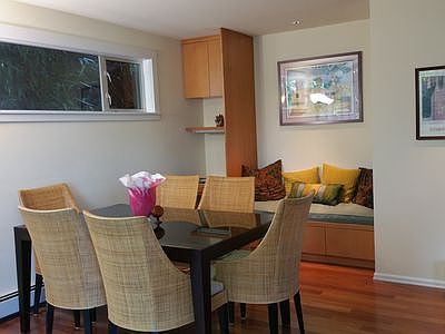 dining area, built in sitting area, fire place is right of the picture with a TV screen above the fireplace.