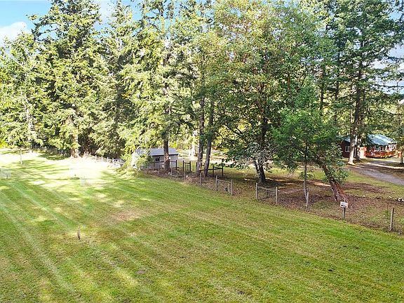 Large fenced pasture forms the western edge of the property. Home can be seen through the trees. 