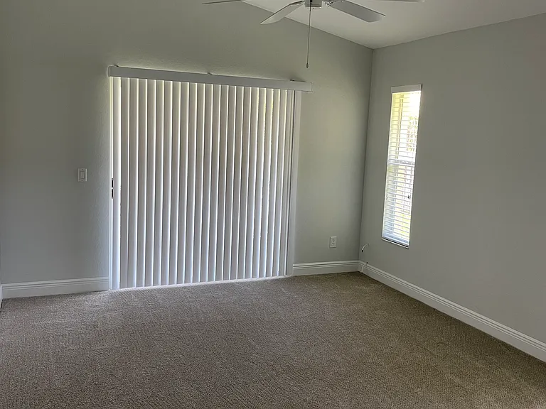 Primary bedroom w/ sliding glass doors to porch.