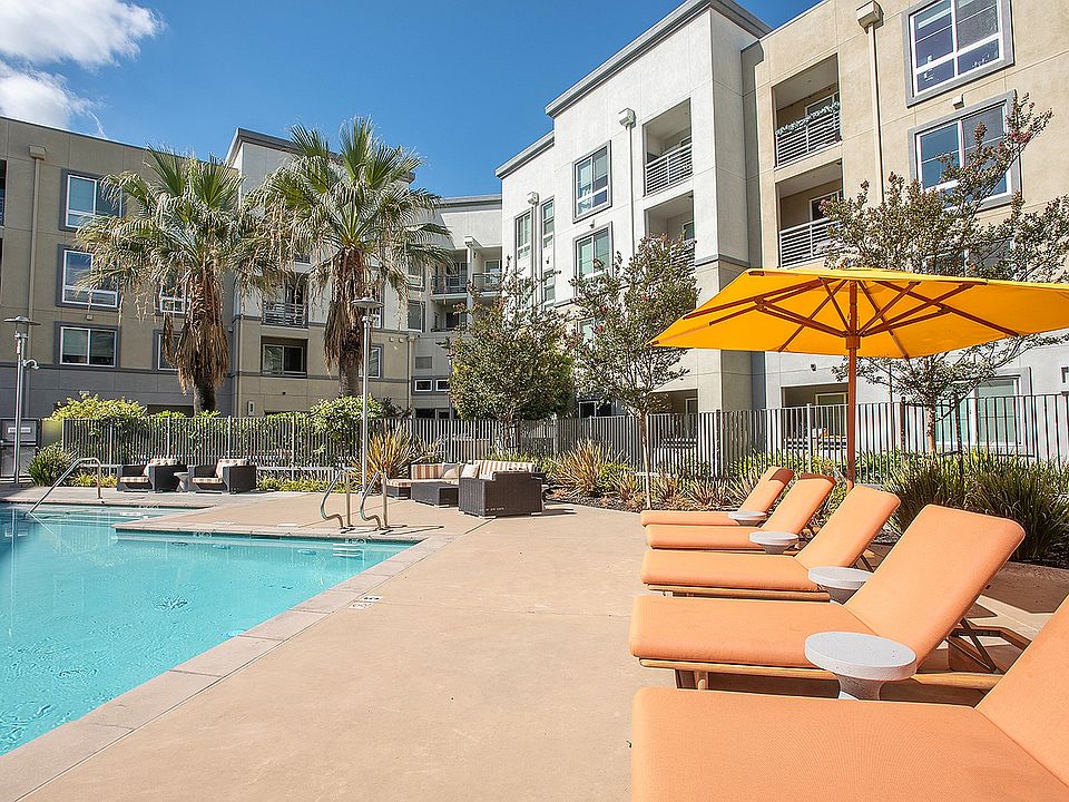 Poolside deck with umbrellas and comfortable seating at Aster Apartments near BART.