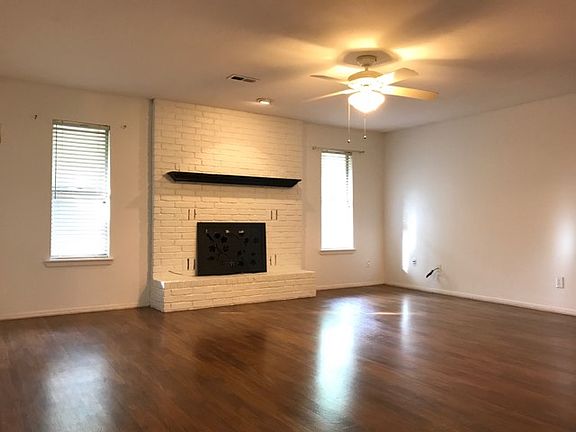 Spacious living room with vinyl plank flooring and gas fireplace.