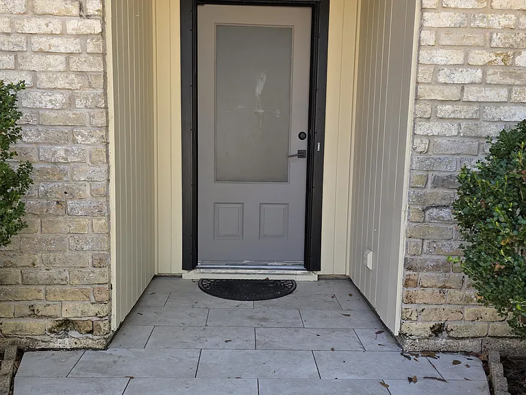 Clean & inviting covered front entryway featuring an updated tile landing.