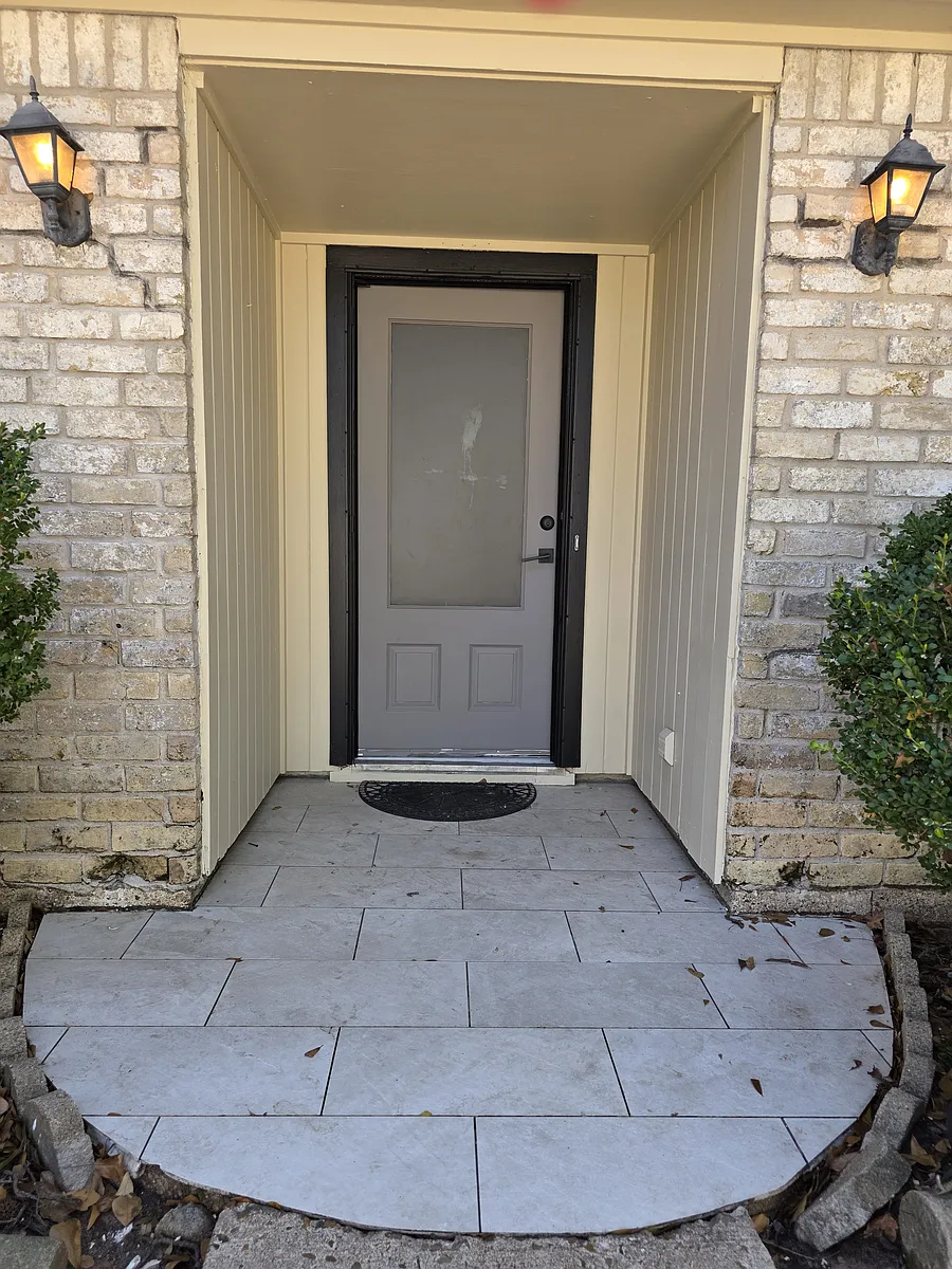 Clean & inviting covered front entryway featuring an updated tile landing. - 8219 Birchglen Ln