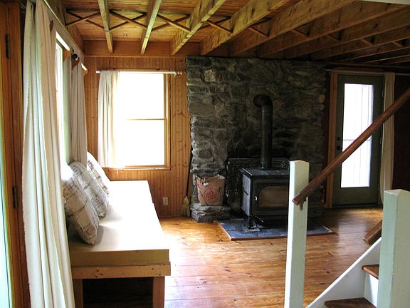 Living room #1 w/ wood stove and beam ceiling