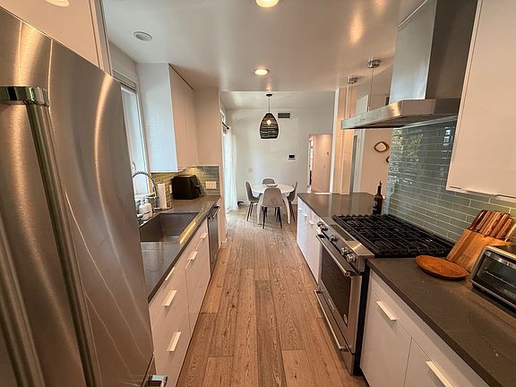 Galley chef's kitchen with Gas stove and stainless hood