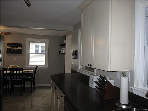 This is a view of the kitchen from the sink area which overlooks the back enclosed porch.  Love the new tiling!  The new countertops!  The eat-in part of the kitchen, too!