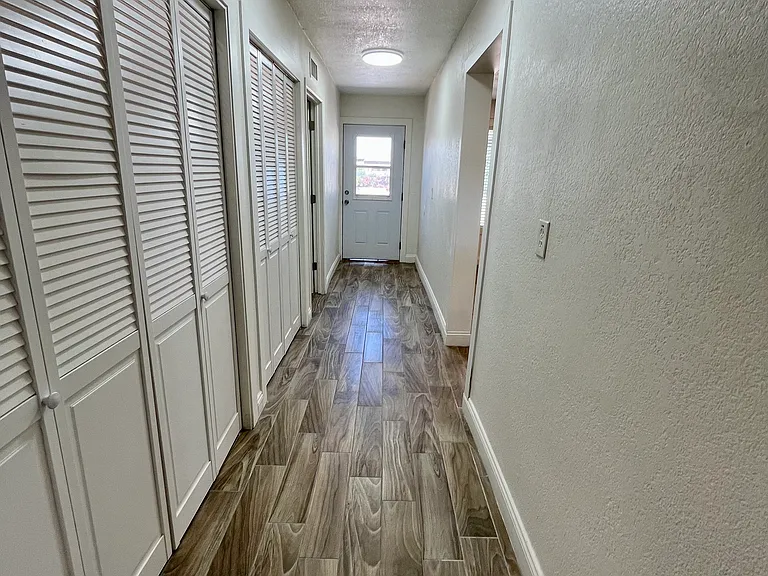Large hallway leads to master bedroom, pantry and exterior door and patio.