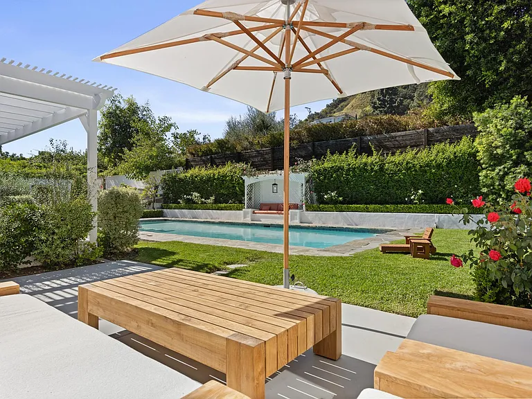 Unwind in this outdoor lounge, where the sun meets comfort, creating a perfect setting by the pool for relaxation.