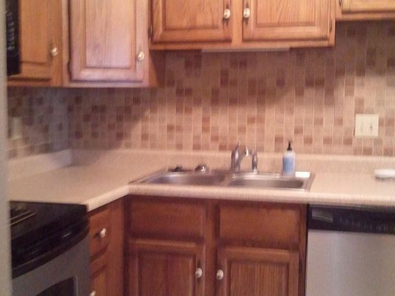 Kitchen with tainless steel appliances and tiled back splash