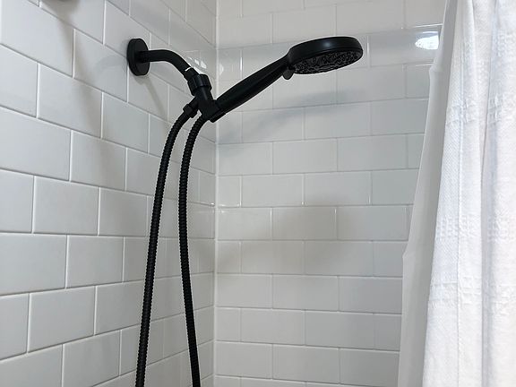 Moen one handle, multi-head round shower, and bath.