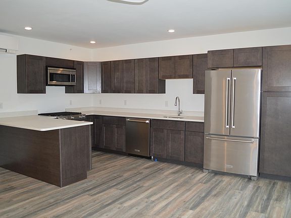 Large kitchen with stainless steel appliances and ample storage (shown unfurnished).