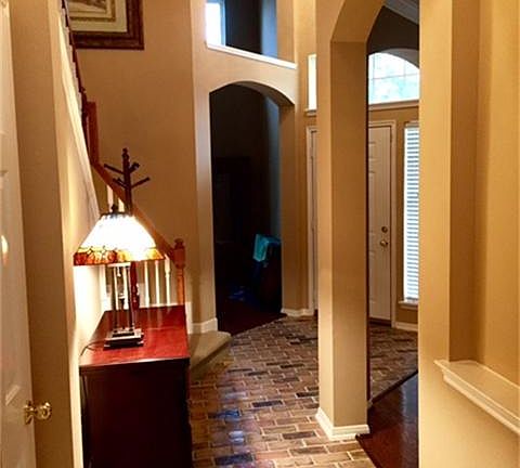 Additional view of foyer coming from the den, featuring arched doorways, direct walk to study and formal dining area.