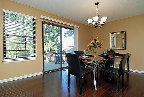 The formal dining room features an elegant chandelier and cherry wood floors. 