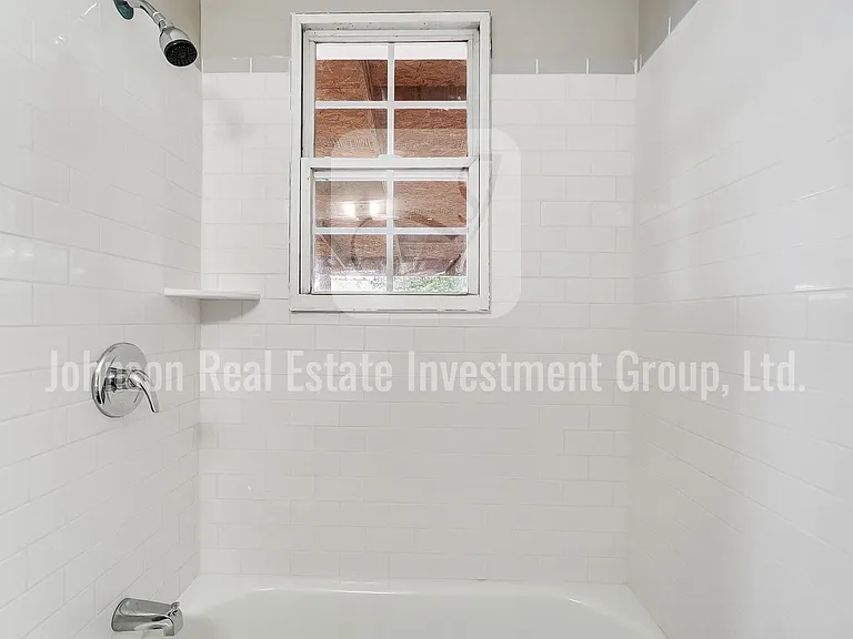 Fully remodeled first-floor bathroom with a pedestal sink and subway tile tub surround.