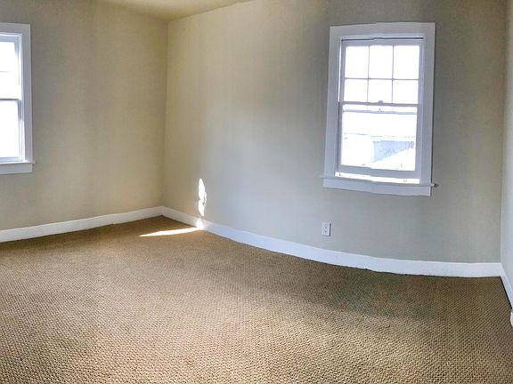 Bedroom with corner windows and peaceful natural light.