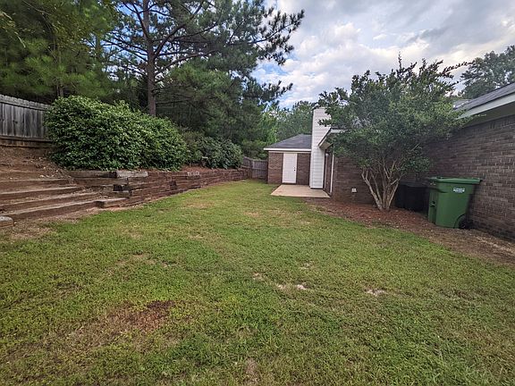 Backyard patio with door to storage.