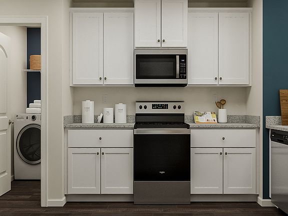 Kitchen has white cabinets and hardware