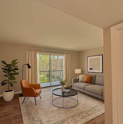 Living room leads out to large screened porch. Staged photo