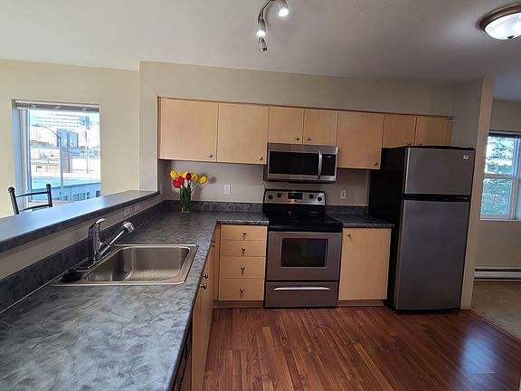 From the hallway looking into the kitchen. Stainless steel stove, refrigerator, microwave and dishwasher.