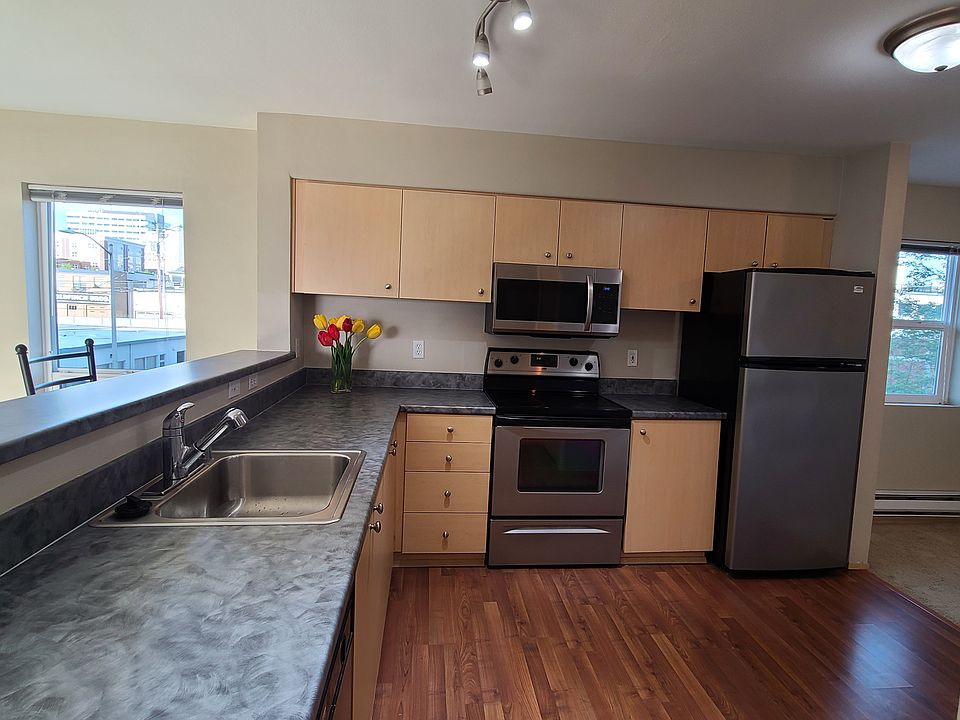 From the hallway looking into the kitchen. Stainless steel stove, refrigerator, microwave and dishwasher.
