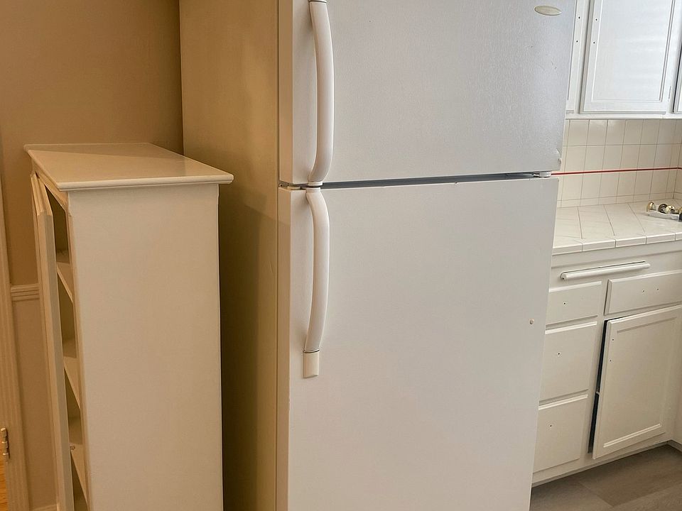 KITCHEN AREA WITH REFRIGERATOR & BUILT IN CURIO CABINET, NEW WOOD PLANK FLOORING.