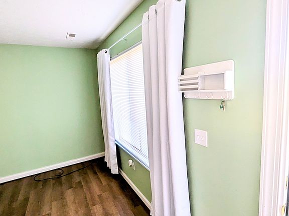 First floor living room; big window with great natural lighting (key holder, blinds and curtains included). All windows in home include screens.