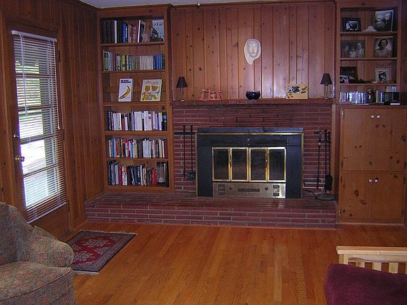 wood panelled den with wood burning fireplace