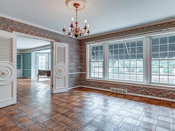 French doors separate the dining room and living room. The large windows overlook the backyard and bring in lots of natural light.
