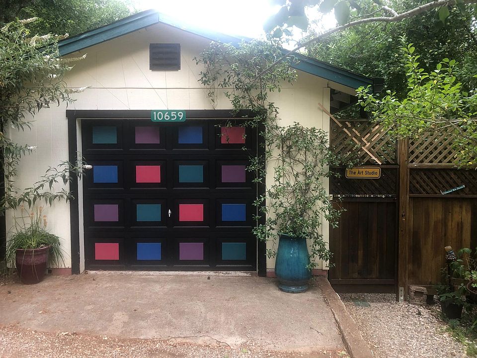 Parking space in front of garage door (where studio is) Entry is to the right through wooden gate.