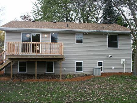 Back view shows more of the mature trees and re-landscaped yard, new deck.