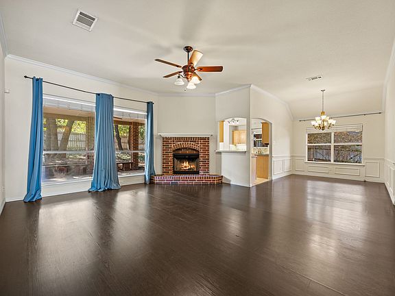 Spacious living area filled with natural light, a cozy fireplace, and beautiful wooden floors.