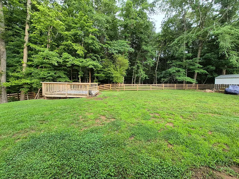 Back yard has a deck in back corner of yard.