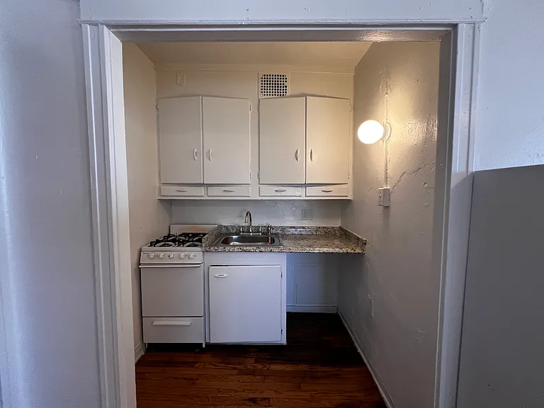 Tiny kitchen has original built-in cabinetry.