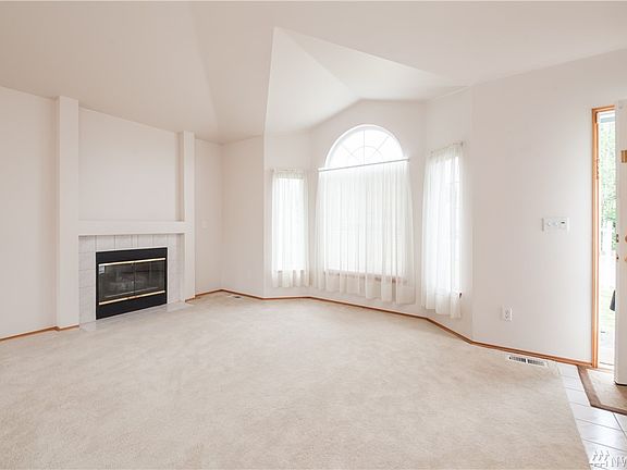 Another living room view, accentuating the bay windows, great natural lighting, and the gas fireplace.
