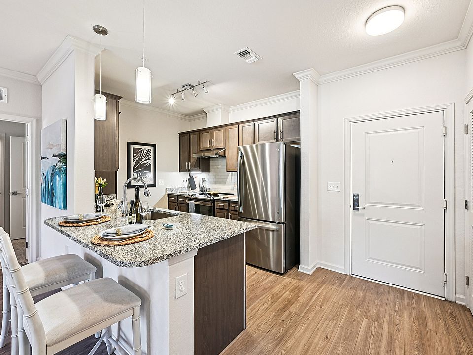 Contemporary kitchen with sleek granite countertops, stainless steel appliances, and inviting breakfast bar with elegant seating.
