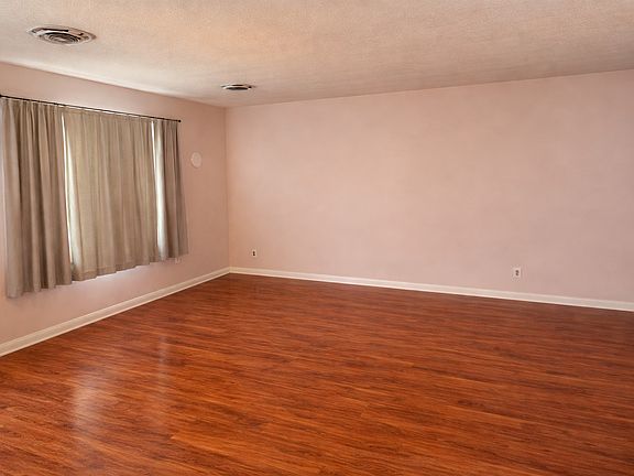 Main Living Room
Bright and expansive living room featuring warm wood-style flooring, large window with natural light, and clean neutral tones ready for your personal touch. Open layout provides flexibility for multiple seating and dining arrangements.