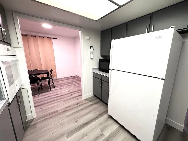 Efficient kitchen with ample cabinetry, full-size fridge, and adjacent dining nook for everyday meals.