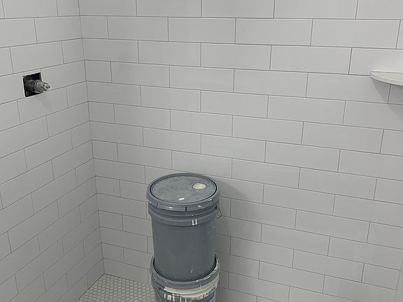 The floors and walls of the shower are tiled.