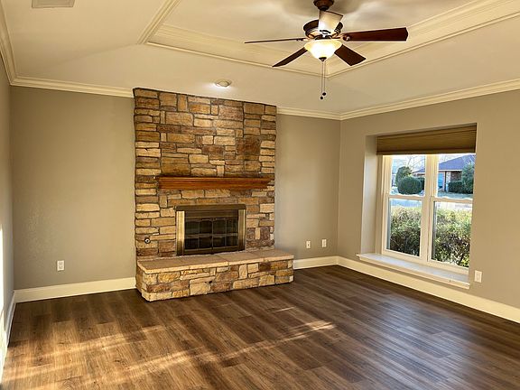 This spacious living room is a great place to relax and entertain. The tray ceiling adds architectural interest, and the floor-to-ceiling fireplace with raised hearth is a cozy feature. The large window lets in tons of natural light.