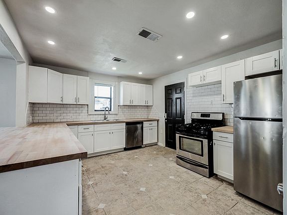 Kitchen with new butcher block counters, subway tile, large farmhouse sink and new cabinets
