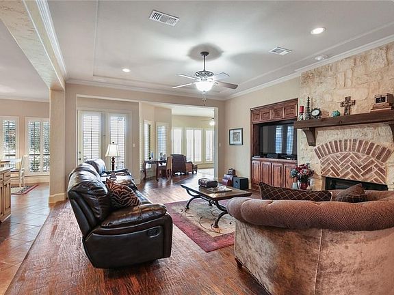Large living room that is open to the kitchen and features a brick and stone fireplace with gas logs. Hand scraped wood floors continue!