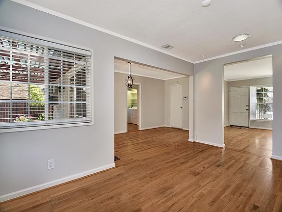 Looking into front room from fireplace. More light from dual pane windows.