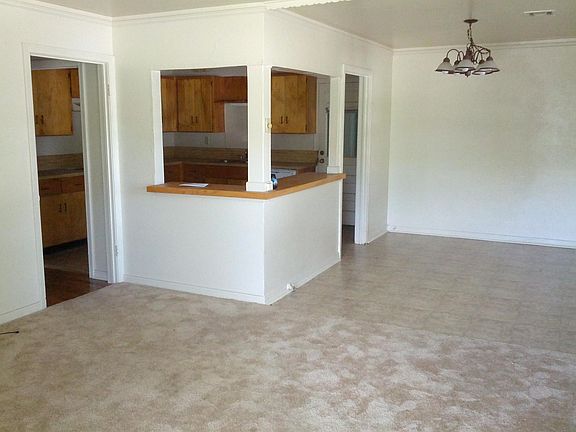 Kitchen opens to Dining area and Living Room, which has hardwood floors now.