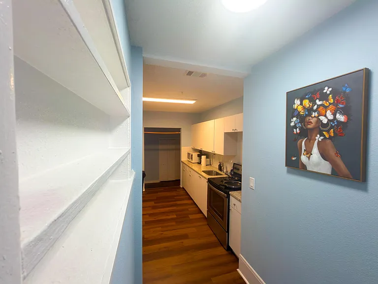 Galley kitchen with ample cabinet storage, full-size range, and generous counter space for meal prep.