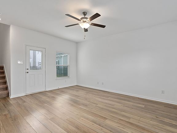 Open family room, with the staircase leading upstairs and a door leading outside.