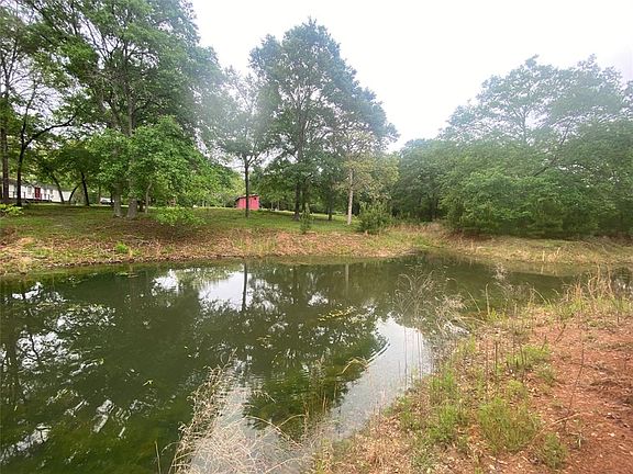Back of property includes pond with magnificent oak tree island.